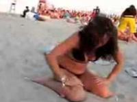 Pijana kobieta na plazy bawi sie w strusia 