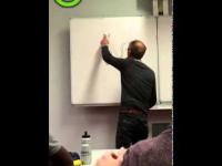 Nauczyciel odkrywa na tablicy narysowanego kota