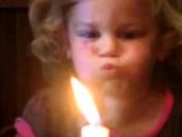 Dziewczynka próbuje zgasić świeczkę
