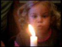 Dziewczynka próbuje zdmuchnąć świeczkę