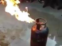 Opalony policjant pokazuje jak zgasić płonącą butlę LPG