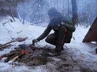 Survivalowy posiłek w lesie. Ogień na śniegu