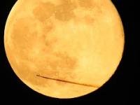 Samolot przelatuje przed Księżycem