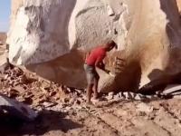 Mężczyzna łamiący wielką skałę