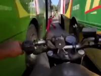 Motocyklem pędzi między autobusami